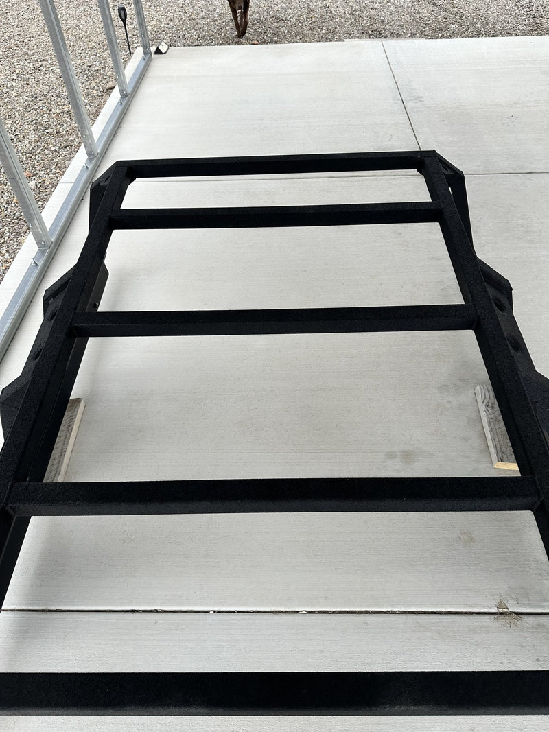 Looking down onto the rack from above showing the flat crossbar deck, the rhino lined black texture finish and the clean uncut tube tops with nothing ever mounted to them — photo 4