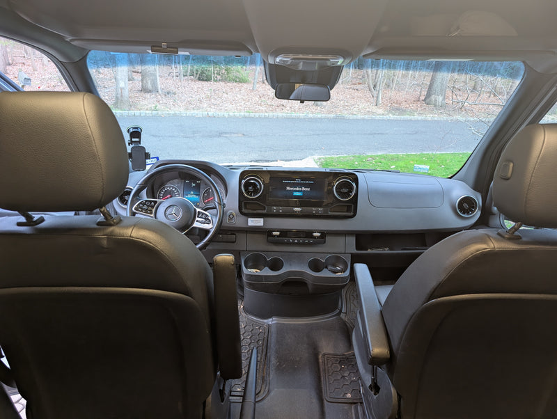 View from rear of an RV rental: Mercedes-Benz Sprinter van cockpit with dashboard, steering wheel & front seats. — photo 12