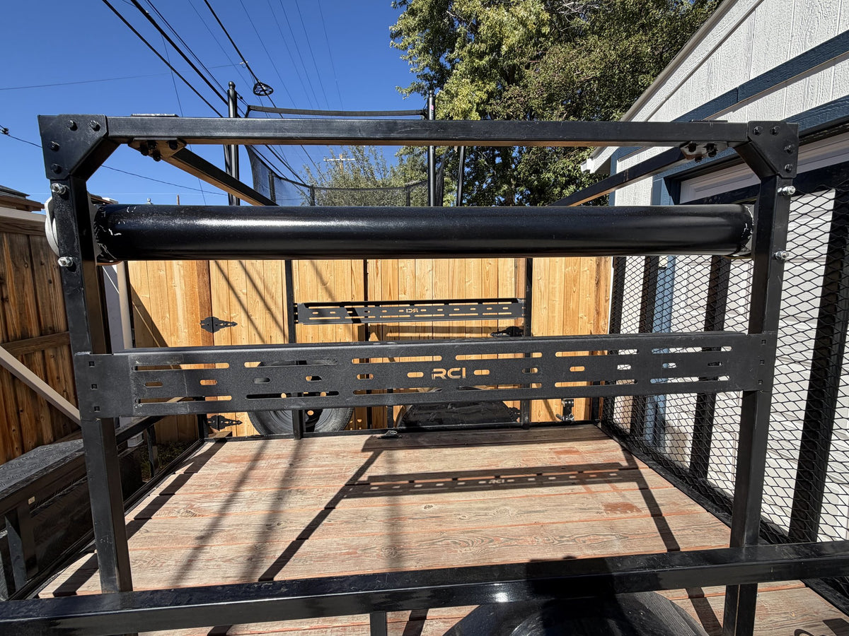 Close view of the front rack panel showing the slotted RCI crossbar, the black roller bar mounted across the top of the frame and the bolted gusset corners of the overhead rack — photo 9