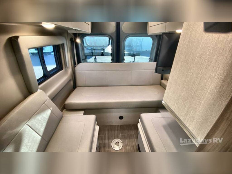  surrounded by lush trees and a white fence.|Compact RV rental wet bath with toilet — photo 12