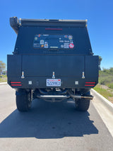 Back of a black "Go Fast Campers" overlanding rig, featuring custom lights. An ideal rv rental for your next outdoor adventure.