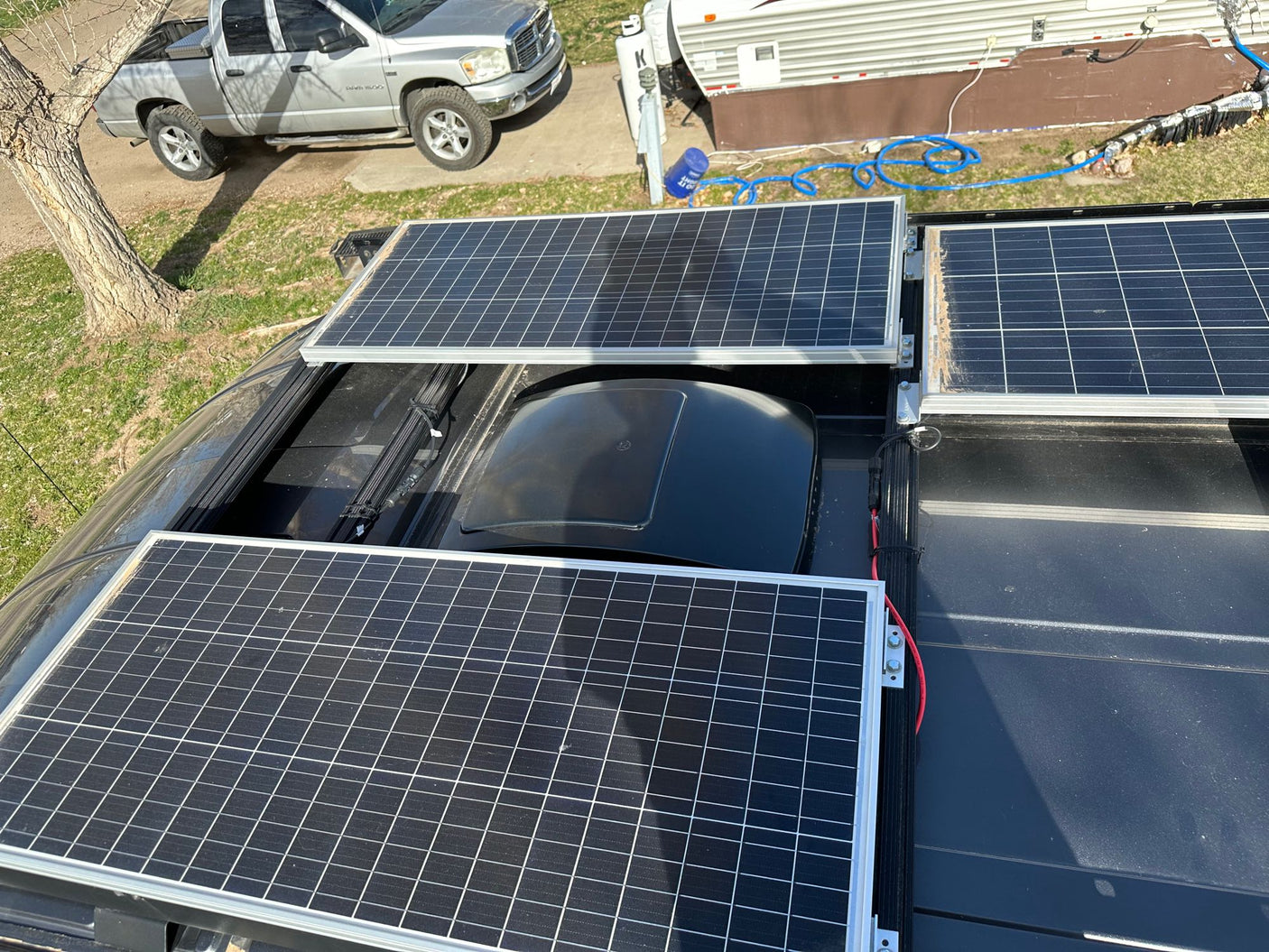 Overhead view of an RV rental roof with three solar panels and a vent, providing off-grid power for adventures.