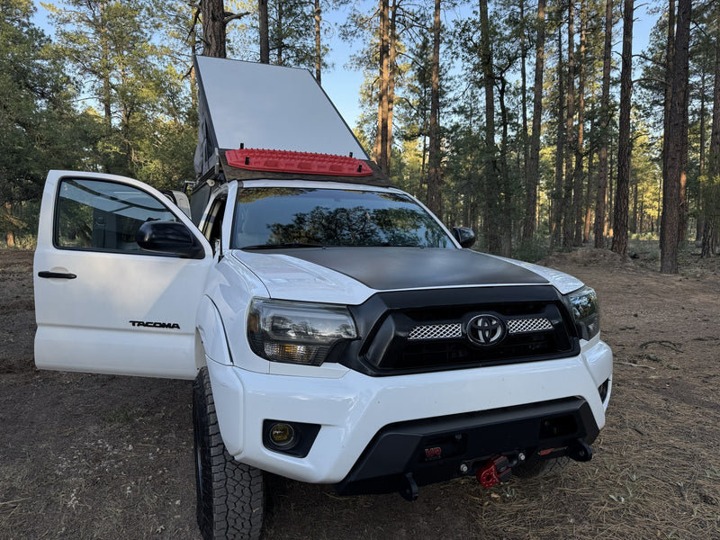 White Toyota Tacoma with open rooftop tent, red traction boards, & off-road gear. Great for an RV rental adventure! — photo 11