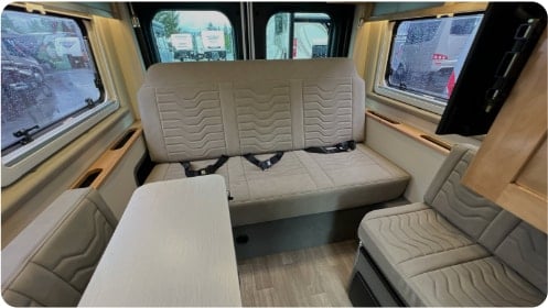  and comfortable living area.|This RV rental interior features comfy bench seating with seatbelts — photo 5