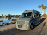 Sleek gray Mercedes-Benz van, ideal for rv rental, parked by a sunny bay with palm trees. Adventure awaits!