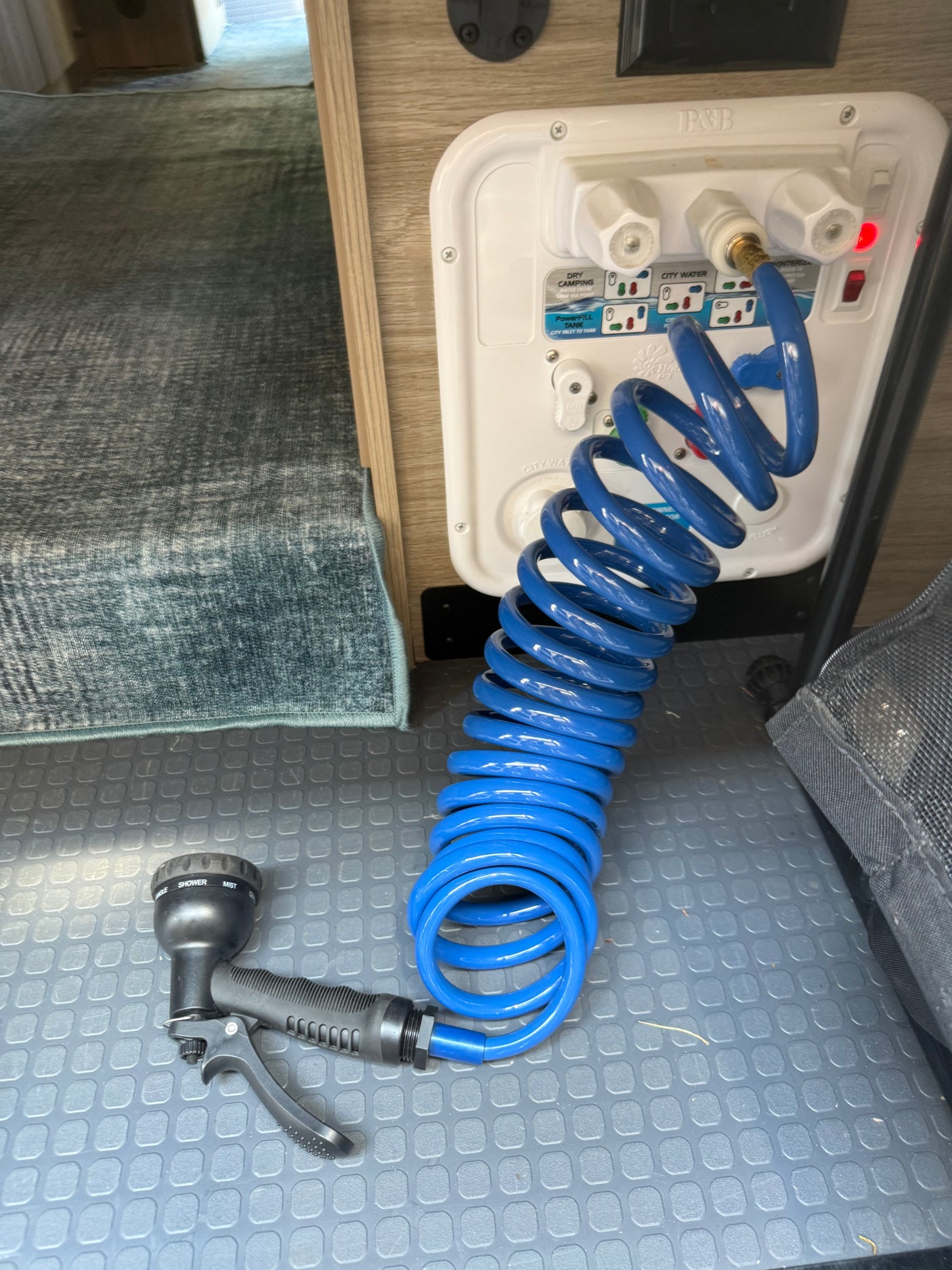 Handheld water hose, spray nozzle, and hot and cold water for showering or washing off at the rear of the van. 