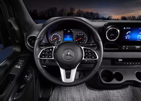Comfortable RV rental interior: A Mercedes-Benz steering wheel and modern dashboard with digital displays and infotainment system.