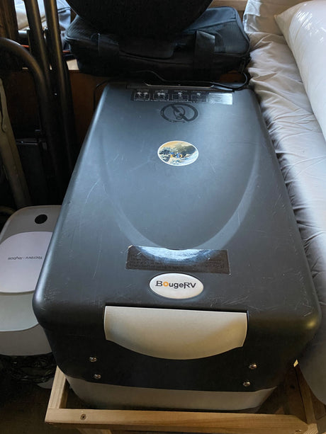 A dark gray BougeRV portable refrigerator/cooler, essential for an RV rental, sits ready for use in a compact living space.