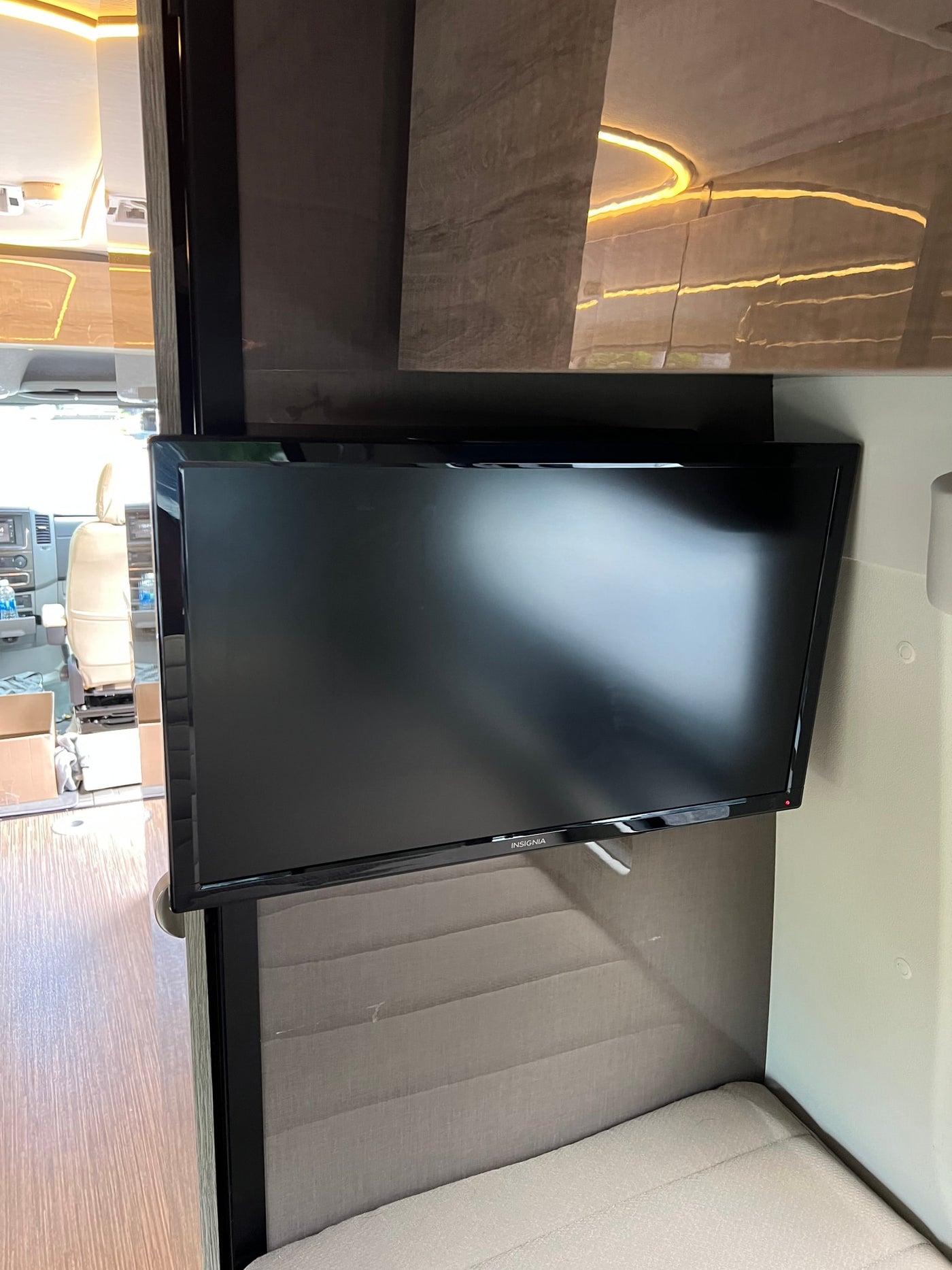  flanked by large windows showing parked cars and trees.|Comfortable modular bed in this rv rental — photo 16