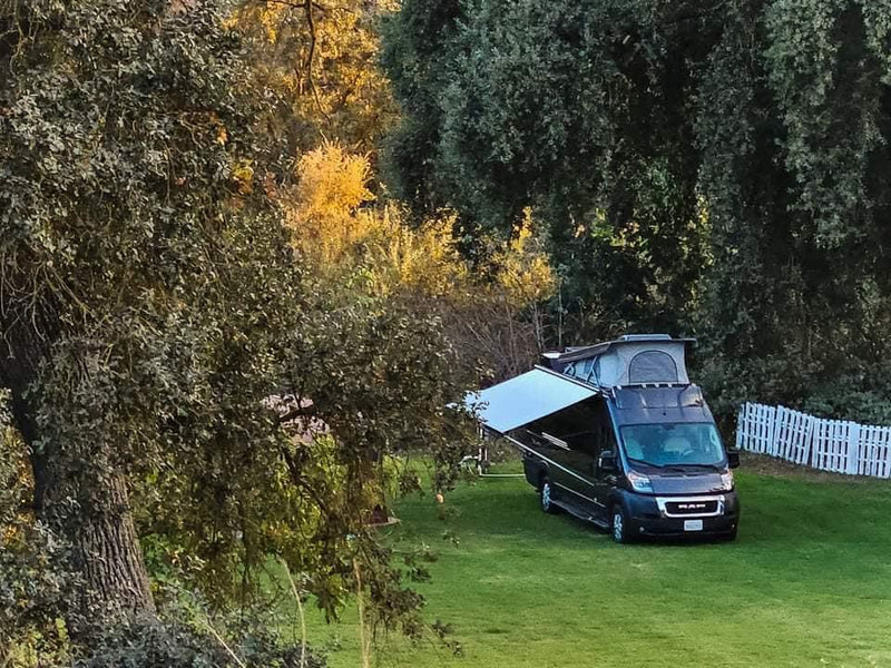  and cargo box on a green lawn.|Moonlit night camping with an RV rental — photo 7