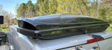 Sleek black roof cargo box on a silver RV, offering ample storage for your next rv rental adventure.