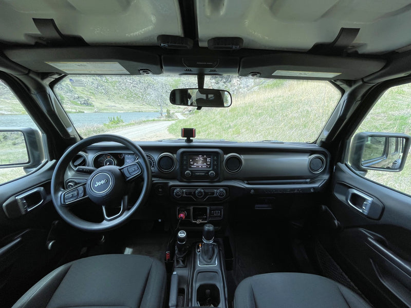 Jeep Wrangler interior, steering wheel visible. Scenic view of a lake & dirt road. Perfect for off-road travel or an RV rental adventure. — photo 14