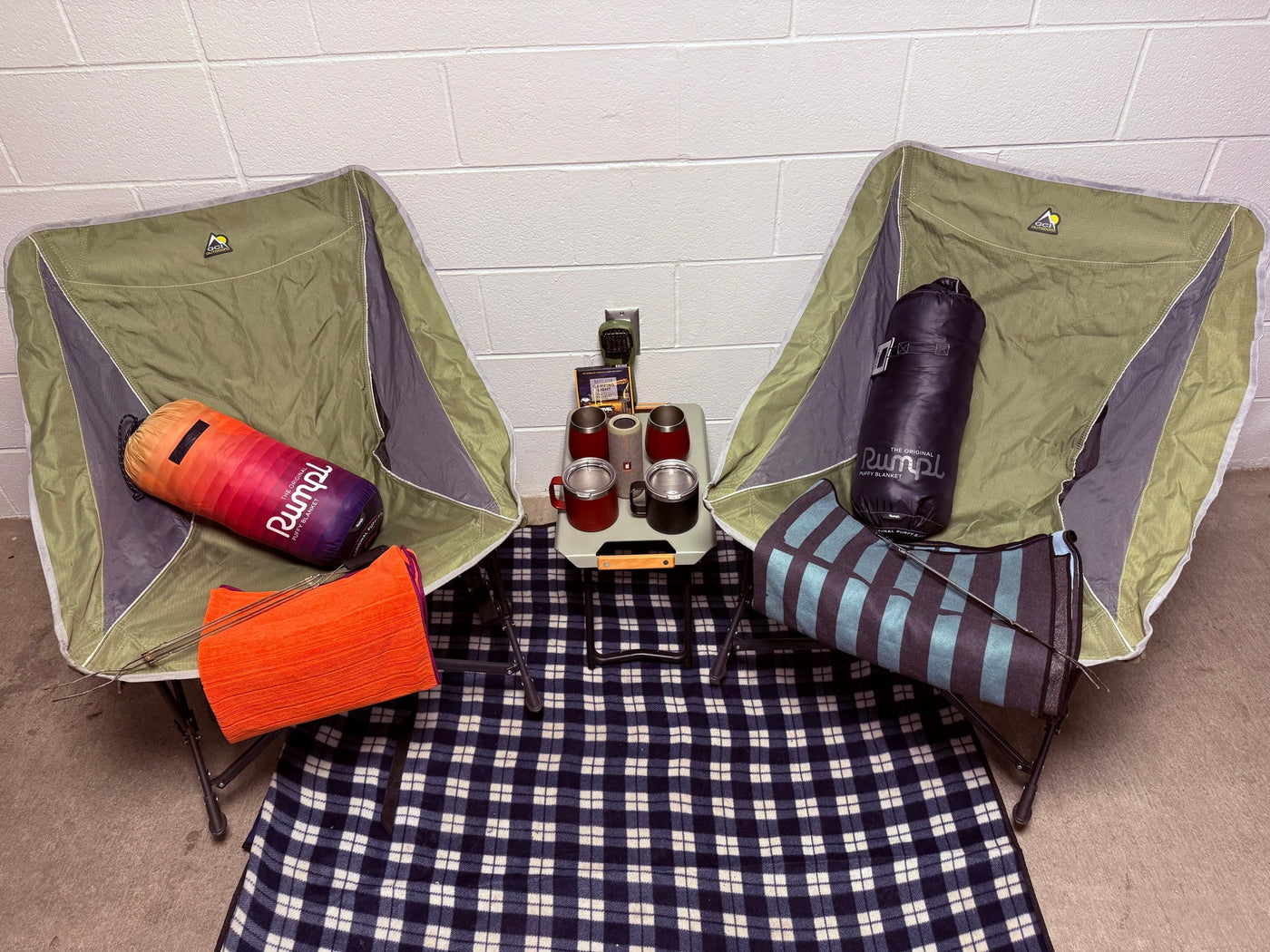 Cozy rv rental setup with two camping chairs, Rumpl puffy blankets, a plaid throw, and essentials for outdoor comfort. — photo 8