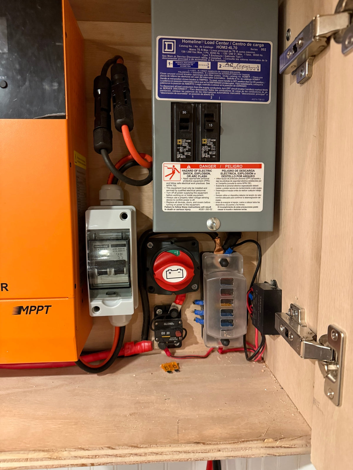 RV rental electrical setup: MPPT solar charge controller, breaker panel, battery switch, and fuse block inside a wood cabinet. — photo 5
