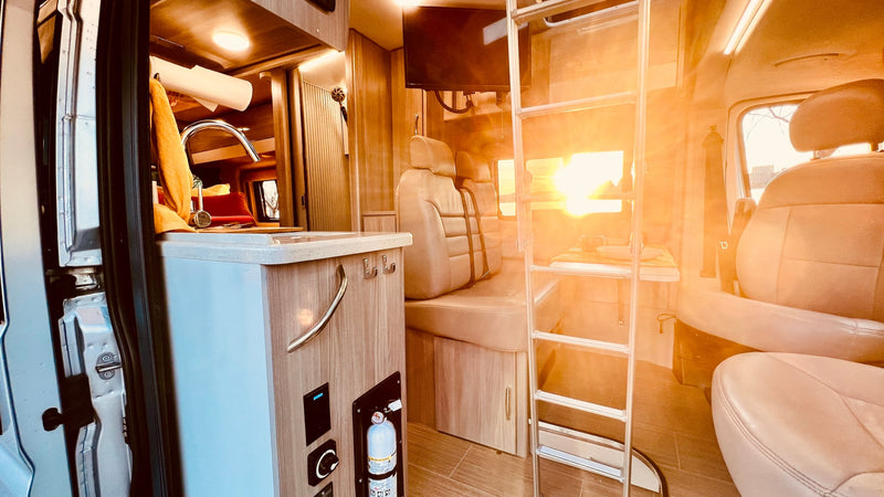 gathered under its awning with drinks in a brightly lit parking lot.|Enjoy nature with an rv rental! White camper van in a sunny green field — photo 8