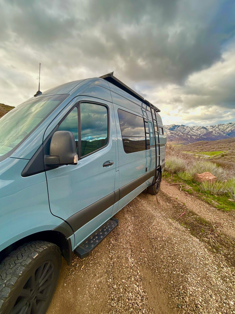 Experience nature! This modern blue-grey RV rental van is parked on a dirt road, overlooking snow-capped mountains. — photo 6