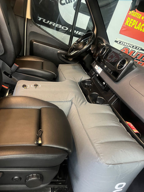 RV rental ingenuity: An inflatable mattress fills the front cab of a van, creating a comfortable bed for road trips.