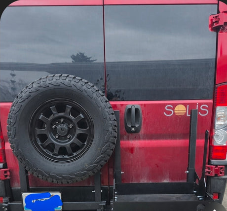 This red RV rental van features a rear-mounted spare tire, 'SOLIS' branding, & a sturdy gear rack, perfect for road trip adventures.