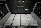 Luxury van RV rental interior: plush quilted beds/seats, TV, and control panel offer ultimate comfort for travel.