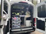 RV rental camper van's organized interior, showcasing efficient storage, portable toilet, and camping gear.