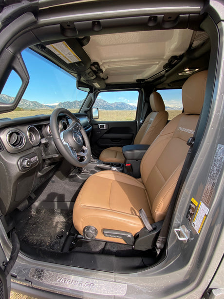 Jeep Wrangler Rubicon's tan interior and mountain view. Ideal for rugged adventure, an exciting alternative to an RV rental.