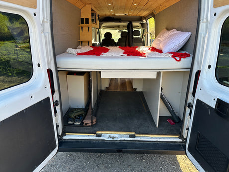 Inside this customized RV rental: a raised bed, spacious cargo area, and built-in storage. Ready for adventure!