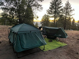 Two elevated tent cots at a sunset campsite. A unique camping experience, perfect as an alternative or addition to an RV rental.