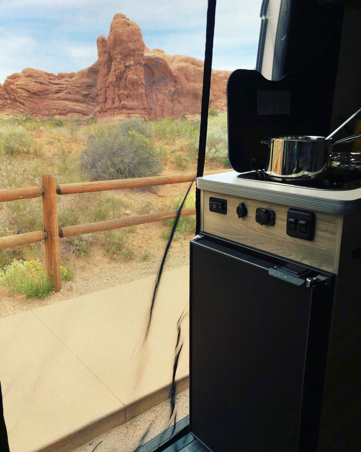  and a serene desert view.|Cozy RV rental interior featuring a cream-colored bench seat with quilted patterns and colorful pillows.|Clean RV rental cabin with swivel front seats — photo 8