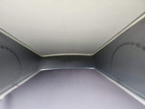 View inside a light grey pop-top RV rental, showcasing the canvas sidewalls, solid ceiling, and bed area.