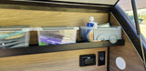 RV rental interior showing smart storage with kitchen utensils & soap, power outlets, and a view outside.