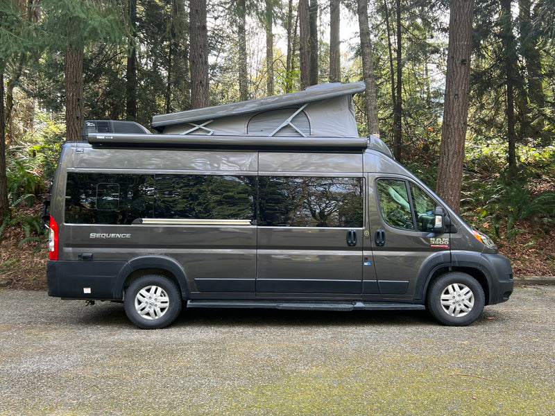 Grey Sequence camper van with pop-top roof parked in a lush forest. Perfect for an RV rental vacation. — photo 15