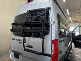 Silver Mercedes-Benz Sanctuary 4x4 camper van with a bike rack, ideal for an RV rental.