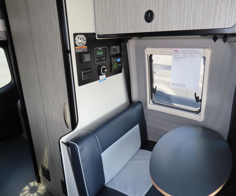  bed with checkered cover on the right. Overhead AC & storage.|An inviting RV rental bedroom.|Inside an RV rental — photo 14