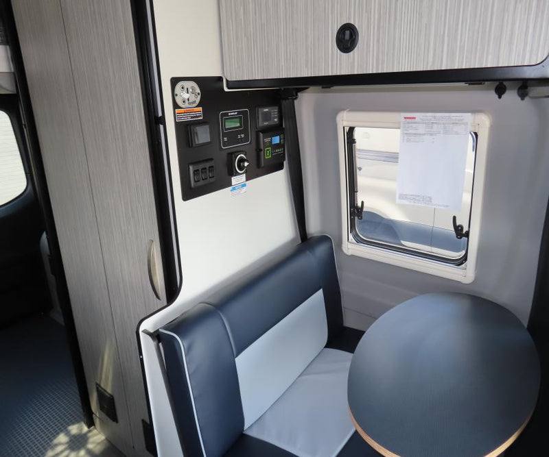  bed with checkered cover on the right. Overhead AC & storage.|An inviting RV rental bedroom.|Inside an RV rental — photo 14