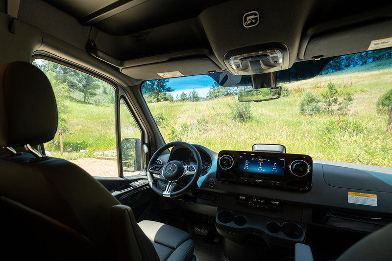 Modern RV rental interior with sleek dashboard and serene green landscape view, perfect for outdoor adventures. — photo 13