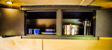 Compact RV rental kitchen with organized Stanley cookware, blue enamelware, and coffee maker, ready for camping adventures.
