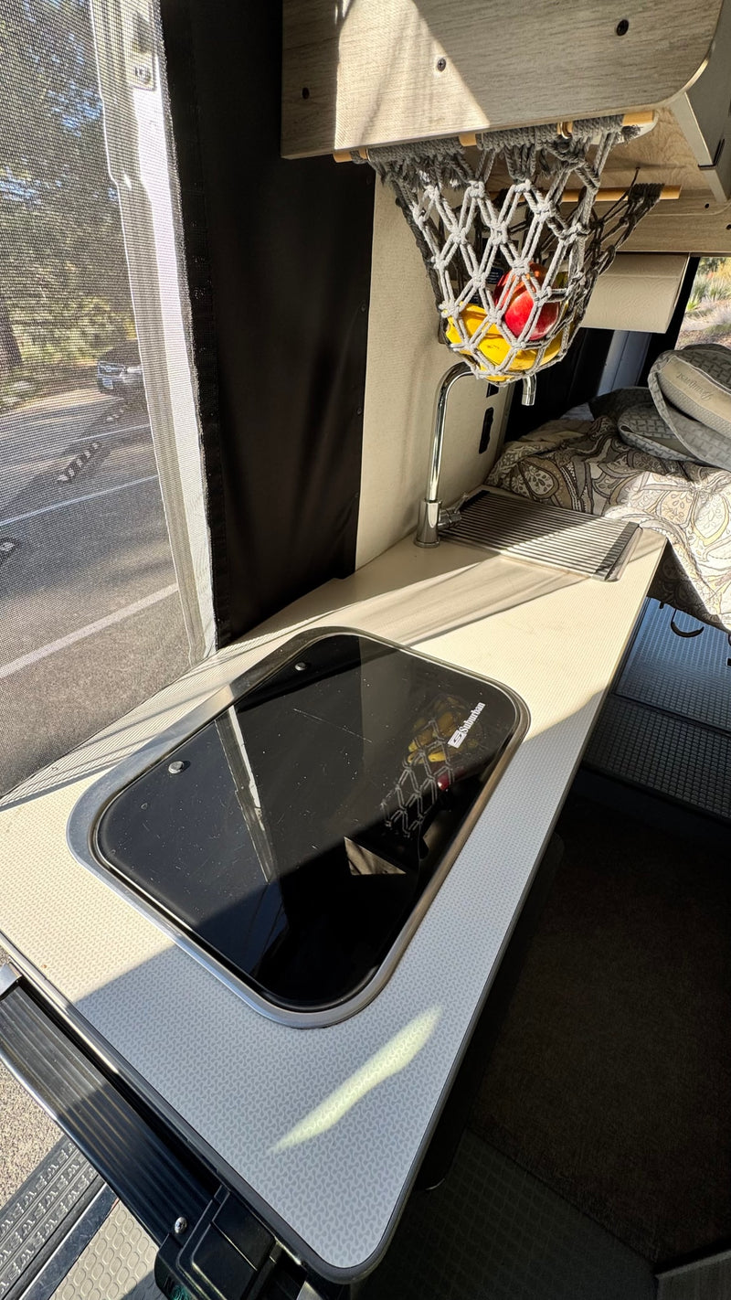  and movable tables for flexible living.|RV rental interior with white quilted seats — photo 19