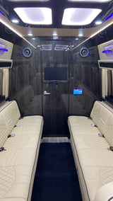 Experience luxury travel in this custom RV rental. Cream quilted seats, wood paneling, and entertainment screen make for premium comfort.
