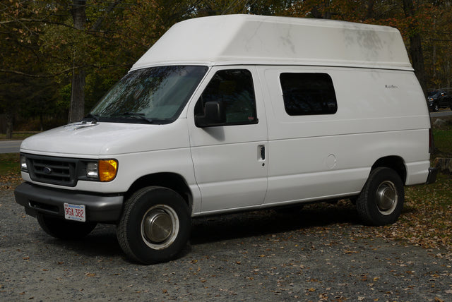 White Ford Econoline high-top camper van, a perfect RV rental for your next road trip.