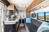 Modern rv rental van conversion interior: compact kitchen, lounge with TV, and ample storage for comfortable trips.