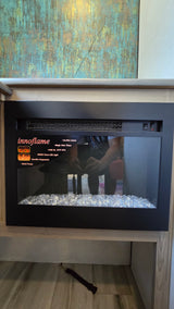 Modern Innoflame electric fireplace, a cozy amenity in this RV rental. Features glass "ice" media and an abstract art backdrop.