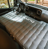 Grey LUNA inflatable mattress filling a Mercedes RV rental van's front cabin. Ideal sleeping pad for van camping trips.