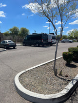 A sunny parking lot features a dark Jayco Swift and a white Solis camper van, indicating RV rental services, alongside other vehicles.