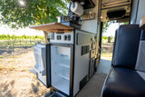 RV rental: Interior kitchen with open refrigerator, sink, and cooking area, overlooking a vineyard.
