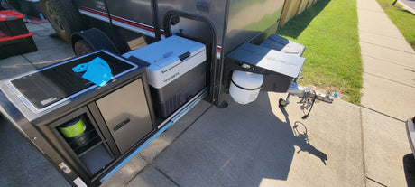 This compact RV rental features a pull-out outdoor kitchen with a Dometic fridge, cooktop, and propane tank, ideal for camping.
