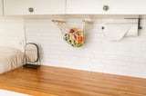 Smart RV rental kitchen design: hanging fruit storage, wood counters, and subway tile backsplash create an organized space.