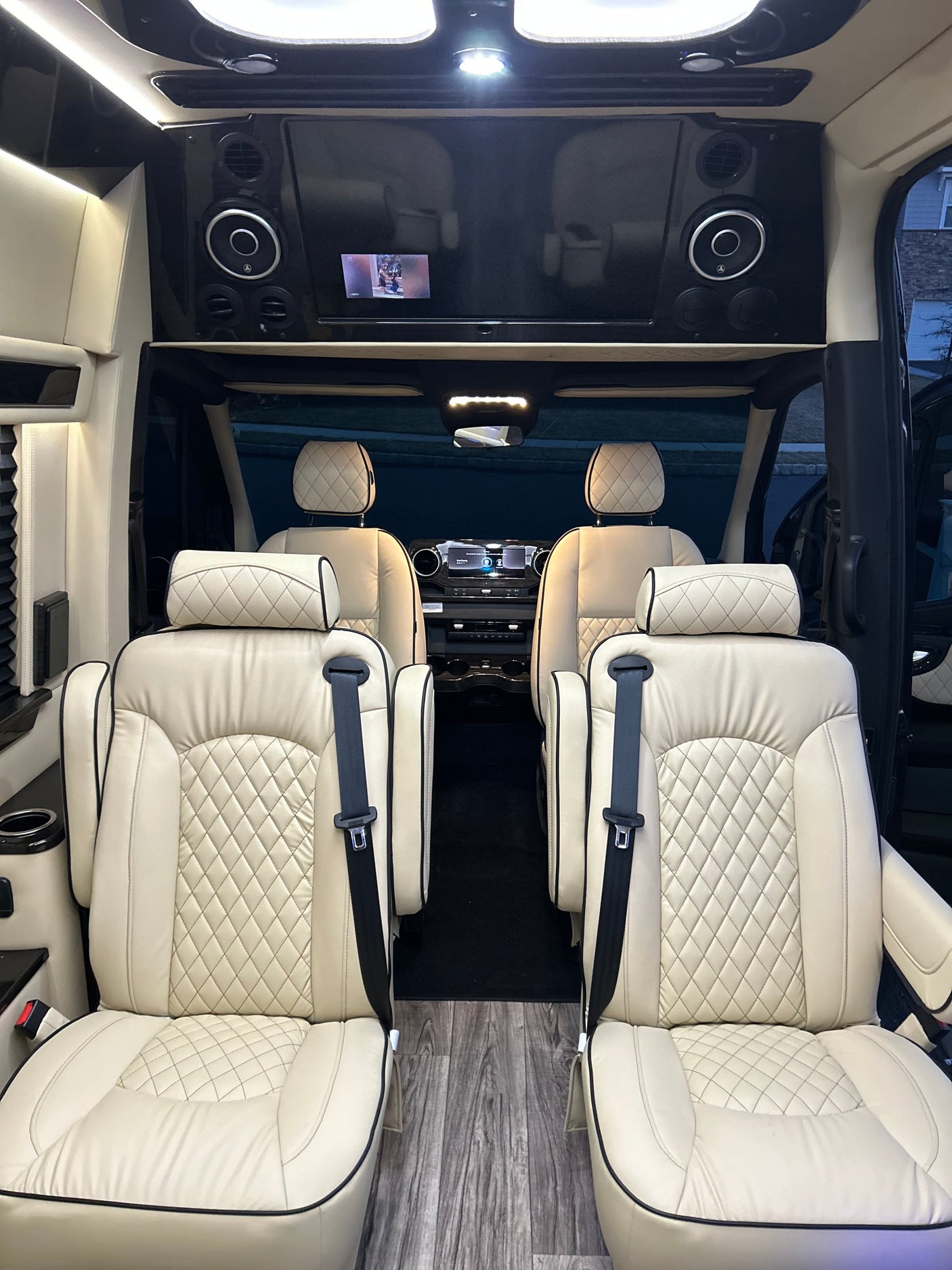 Luxury RV rental interior with plush cream seating and entertainment displays for comfortable travel.