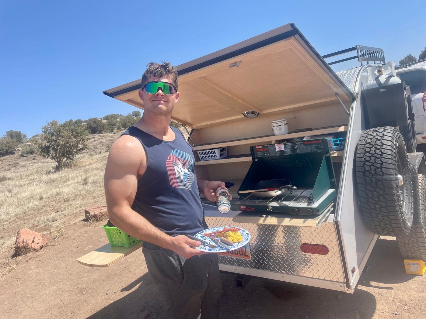 Enjoying an RV rental camping trip! A man cooks breakfast outdoors with a propane stove setup in his compact trailer. — photo 15