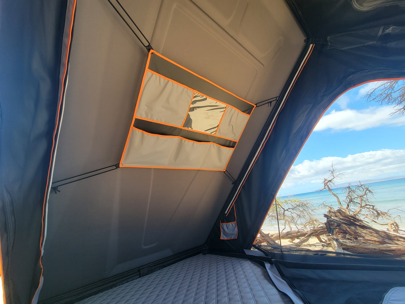 Experience beachfront camping in this RV rental rooftop tent with a comfy mattress, storage pockets, and ocean views.
