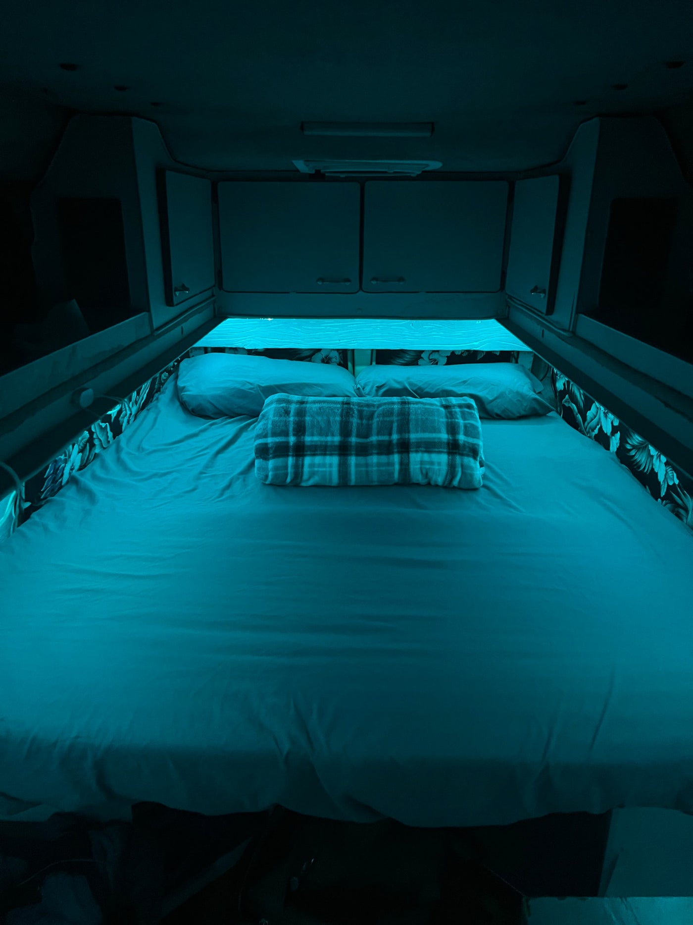  perfect for off-grid travel and exploration.|Cozy RV rental interior featuring a neatly made bed and a compact kitchenette with a decorative basin and faucet.|RV rental kitchen: a compact space with sink — photo 11